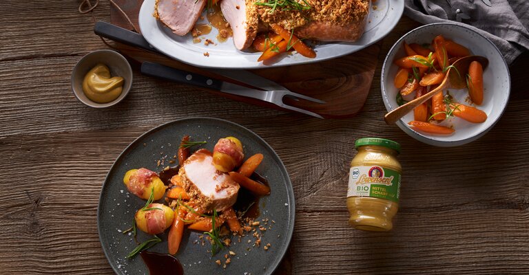 Rosa gebratener Schweinebraten mit Senf-Walnusskruste in Rosmarinsauce auf Honigmöhren mit Löwensenf Bio Mittelscharfer Senf