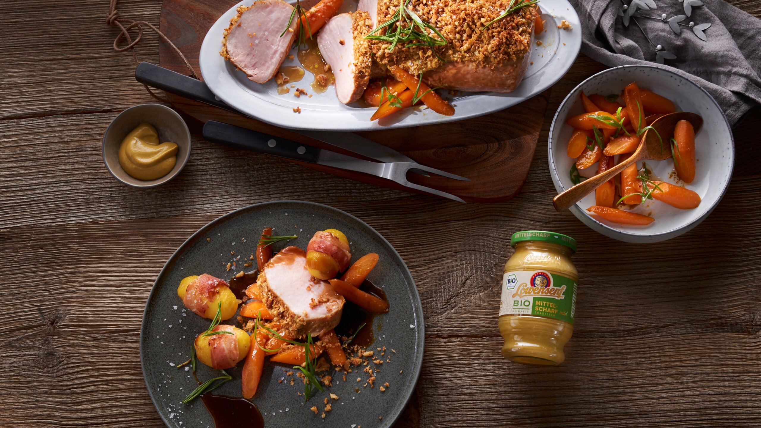 Rosa gebratener Schweinebraten mit Senf-Walnusskruste in Rosmarinsauce auf Honigmöhren mit Löwensenf Bio Mittelscharfer Senf